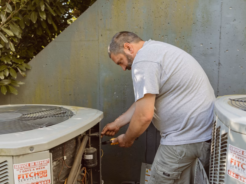 An expert heating and air technician repairs an HVAC system in Charlottesville, VA.